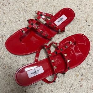 Bright red Valentino jelly sandals with shiny gold studs